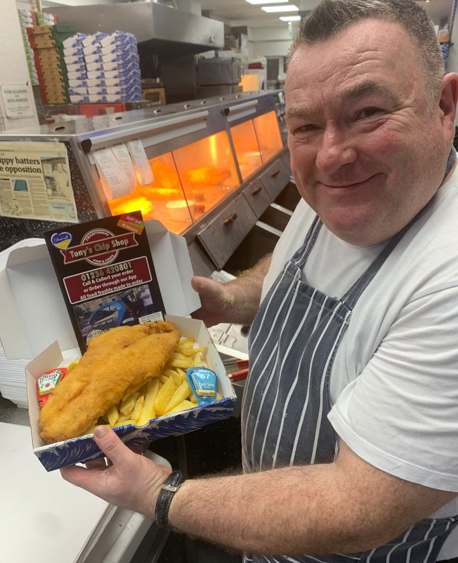 Owner of Tony's Chip Shop in Coatbridge holding fish & chips 